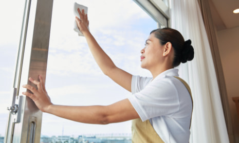 Housekeeper wiping windows